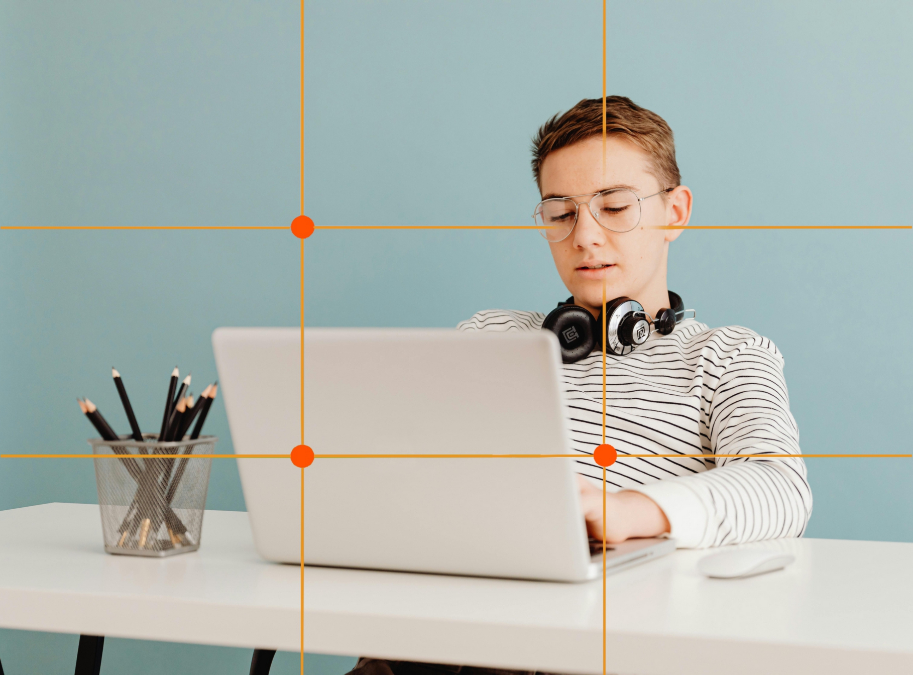 Kuva, jossa nuori istuu tietokoneella ja kuvan päälle piirretyistä huomiopisteistä yksi on nuoren kasvojen kohdalla.